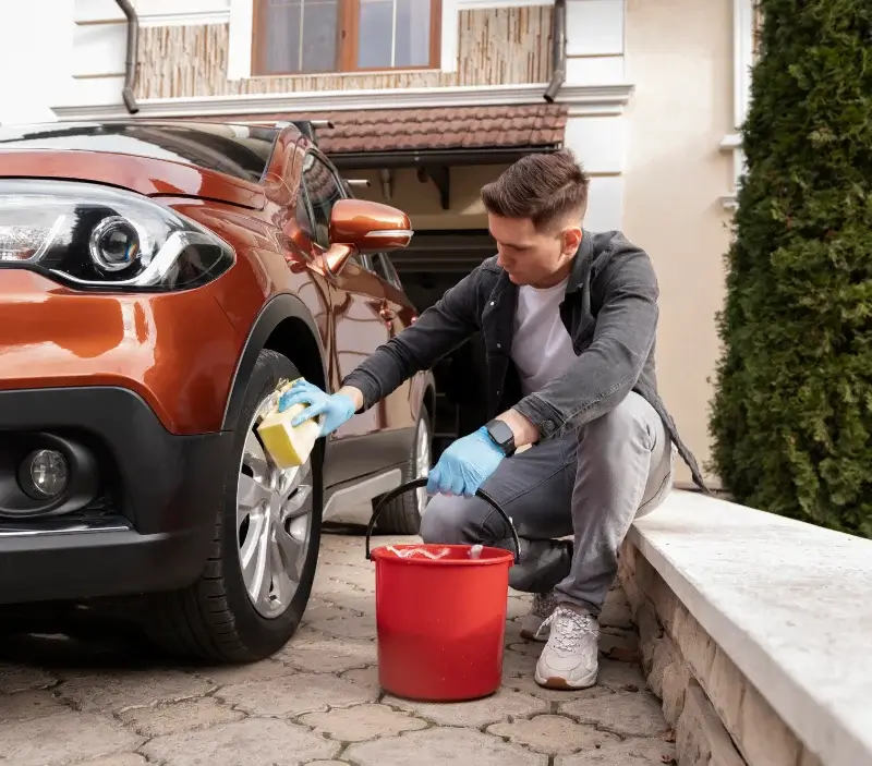 Lavage auto à domicile Cubjac-Auvézère-Val d'Ans : professionnel intervenant sur un véhicule